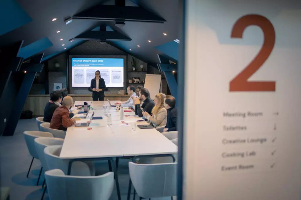Participants réunis autour d'une table à Dijon pour un séminaire, logo Salt & Pepper visible et porte numérotée 2.