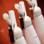 Trois brosses à dents électriques blanches alignées sur fond rouge, avant-plan net, pour atelier culinaire d'entreprise.