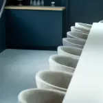 Chaises grises alignées dans salle de réunion épurée, globe et verrerie au fond, lieu séminaire team building Dijon.
