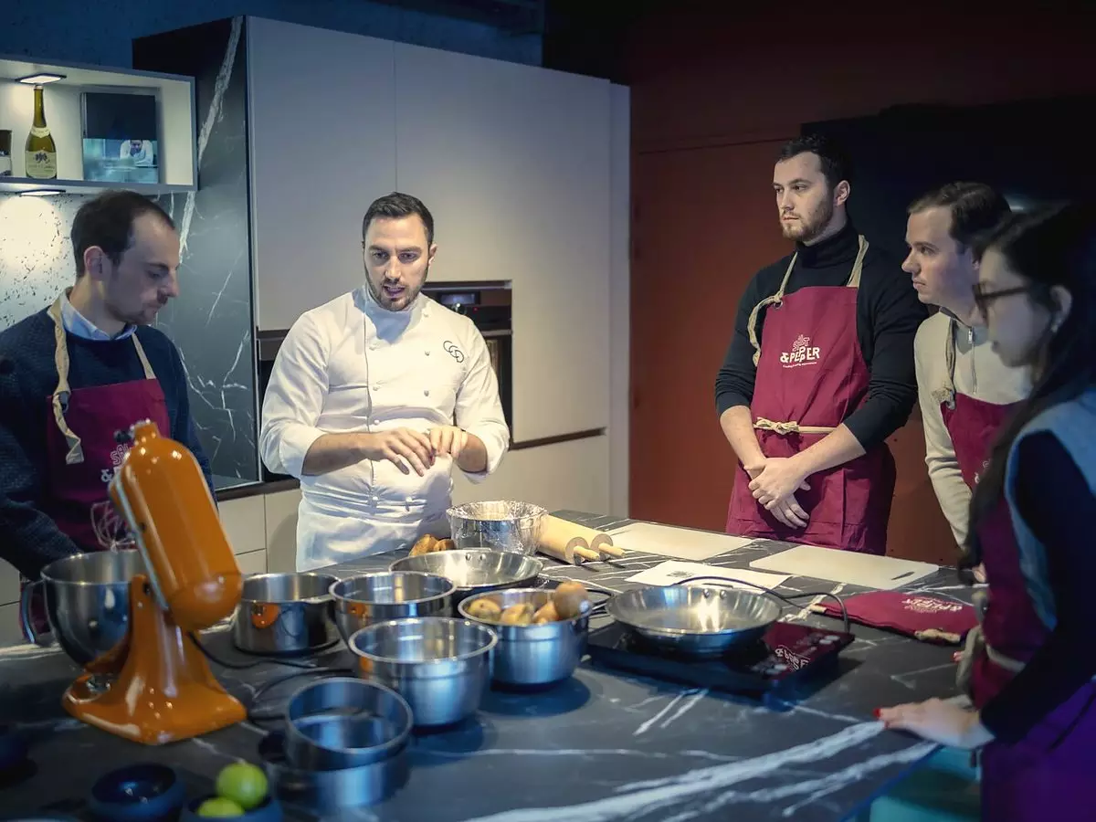 Un chef explique un geste à un petit groupe dans le Cooking Lab de Salt & Pepper à Dijon