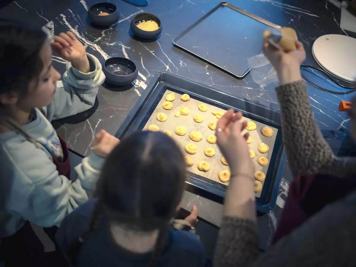 Des enfants garnissent une plaque de choux en atelier de pâtisserie à Dijon