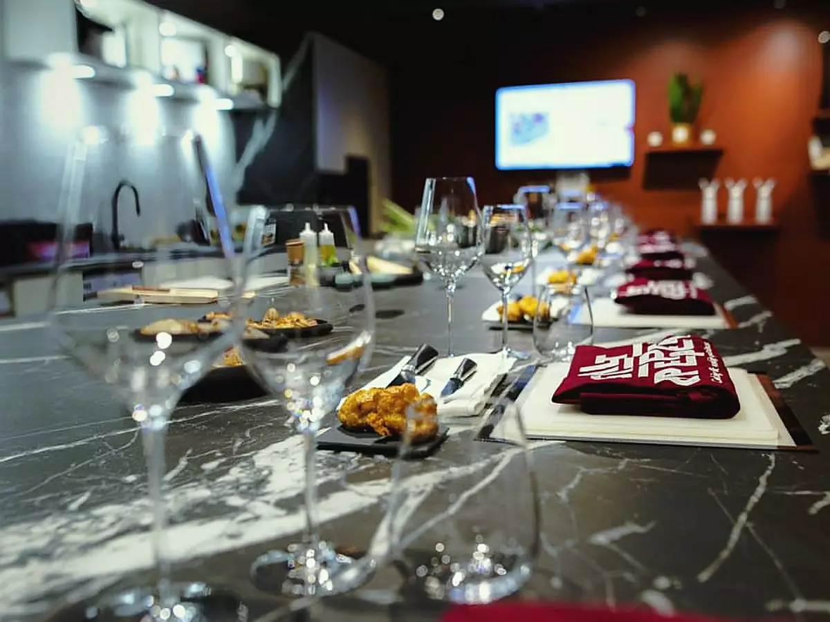 Assiette dressée et verre de vin sur un poste du Cooking Lab de Salt & Pepper à Dijon