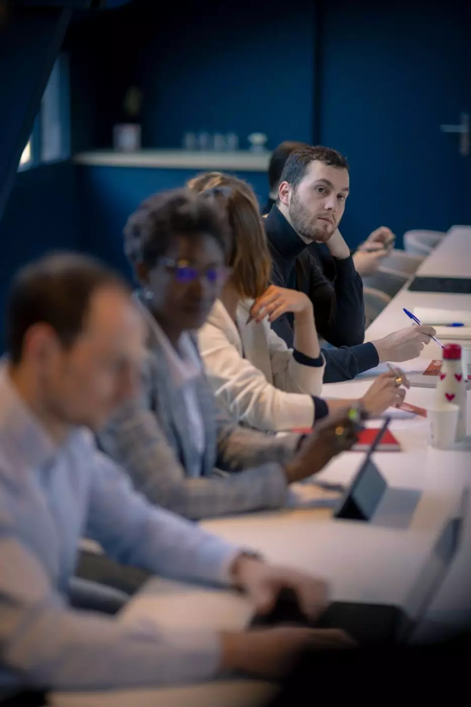 Équipe réunie autour d’une longue table de réunion dans une salle bleue chez Salt & Pepper